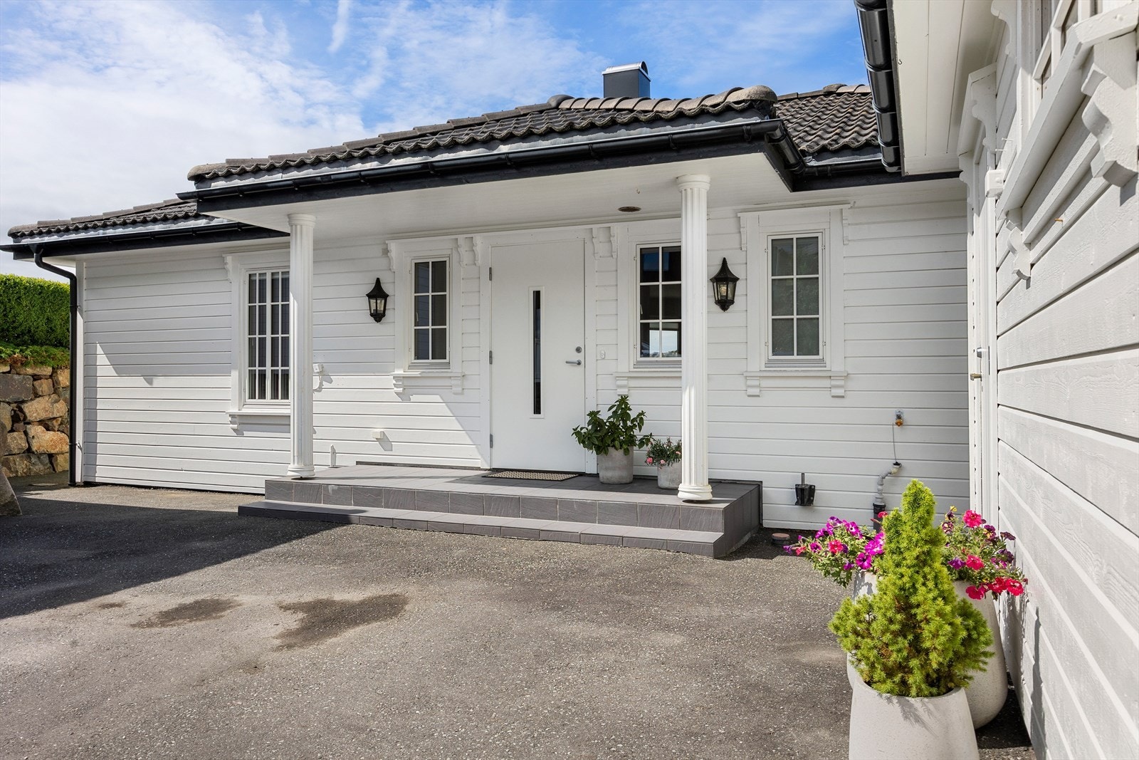 Pent, overbygget inngangsparti som leder inn til boligens hovedetasje. Galleribilde