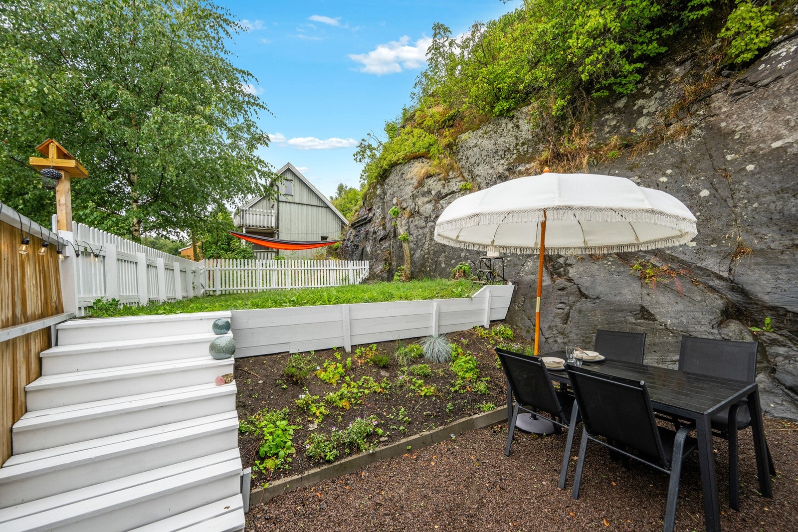 En lettstelt uteplass som passer godt for deg som ønsker hage uten et omfattende vedlikeholdsbehov. Galleribilde