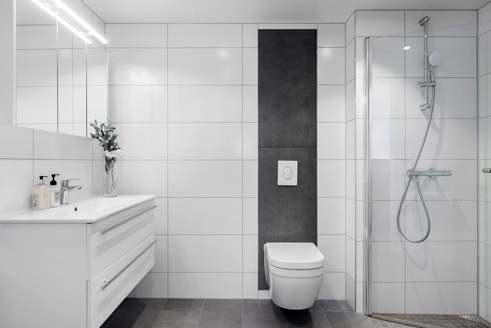 Badet har innredning med nedfelt servant, veggmontert toalett, dusjvegger/hjørne og opplegg for vaskemaskin samt tørketrommel. Galleribilde