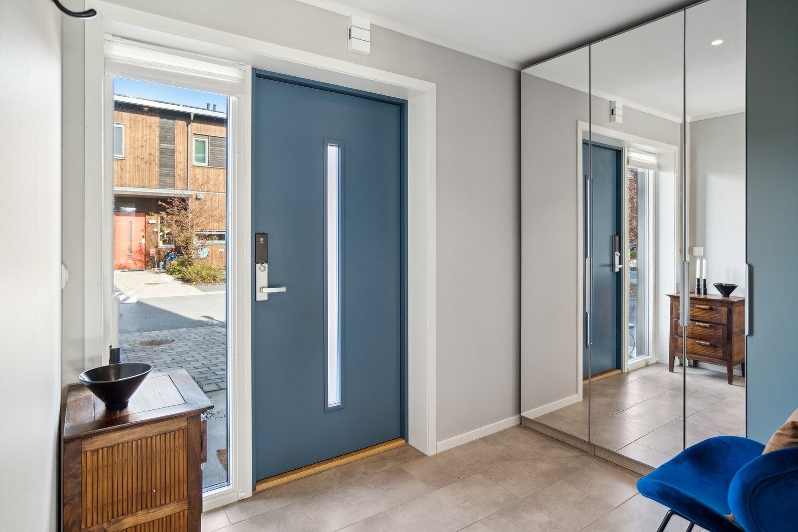 Lys og innbydende entré med flislagt gulv, god garderobeplass og praktisk adkomst direkte fra gårdsplassen. Galleribilde