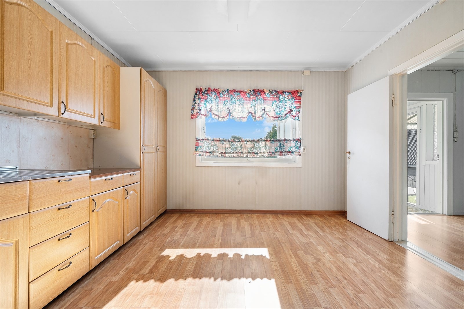 Kjøkkenet har laminat på gulvet og tapetserte vegger. Galleribilde