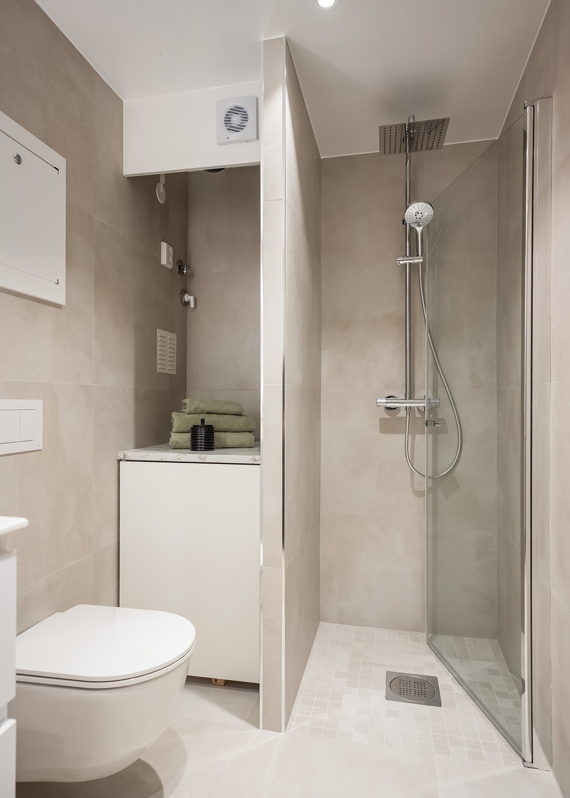 Det inneholder vegghengt toalett, servant med underskap, belysning i speil, og dusjhjørne med glassdører og waterfall dusj. Det er satt inn en praktisk løsning med opplegg for vaskemaskin over varmtvannsberederen. Nytt rør-i-rør og avløpssystem. Galleribilde