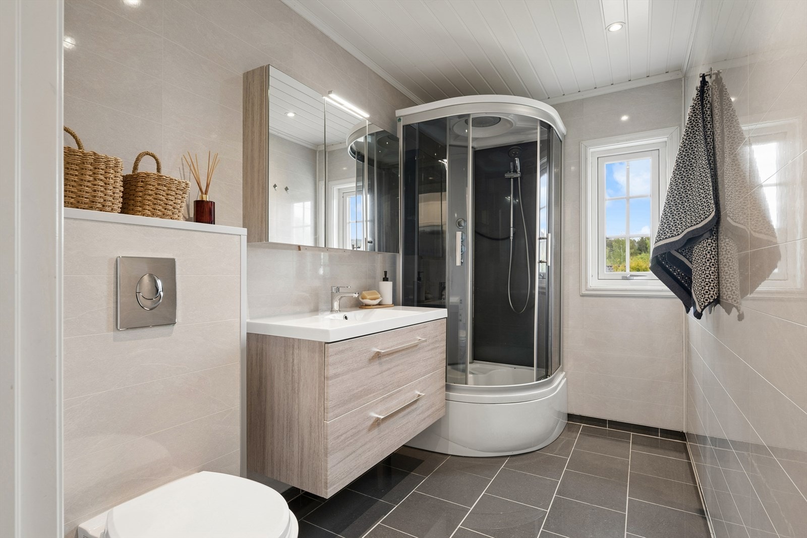 Badet er fra 2019, med våtromsplater på vegg og fliser på gulv. Galleribilde