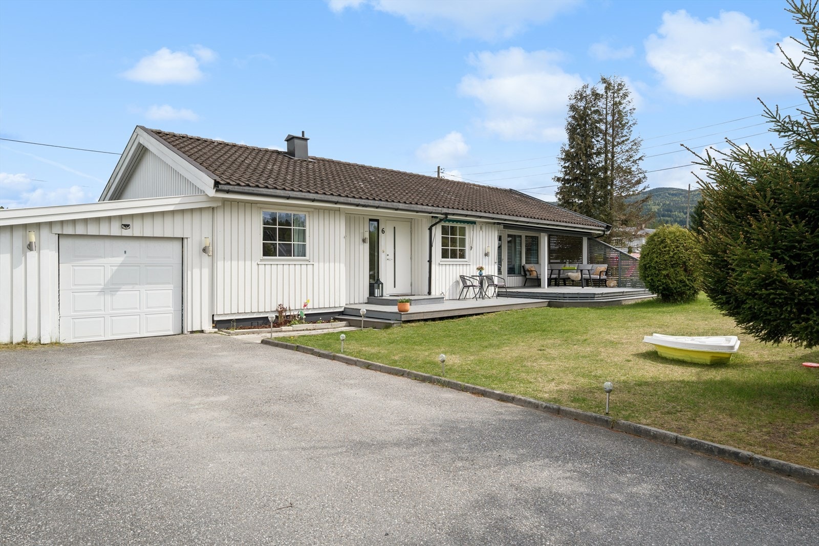 Asfaltert gårdsplass og garasje. Galleribilde