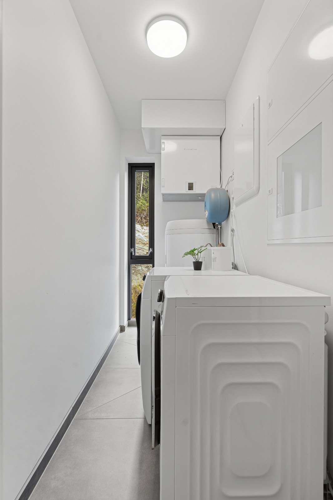Leiligheten har også et eget teknisk rom med opplegg for vaskemaskin, noe som gir en praktisk og ryddig hverdag. Galleribilde