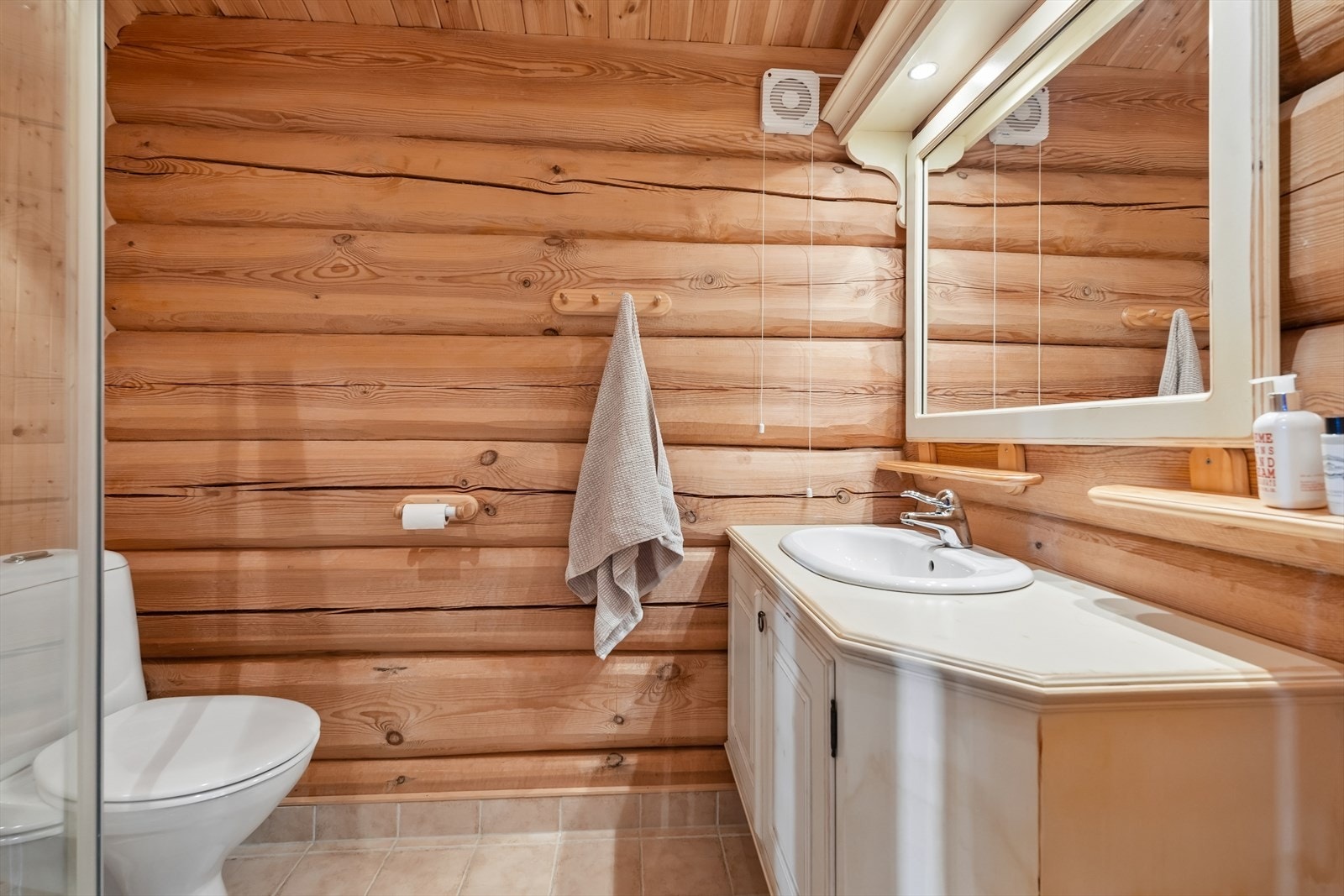 Med bad i begge etasjer er det lagt godt til rette for at fritidsboligen kan benyttes komfortabelt av mange samtidig. Badet har innredning i malt heltre med underskap, speil med belysning, dusjkabinett og toalett. Galleribilde