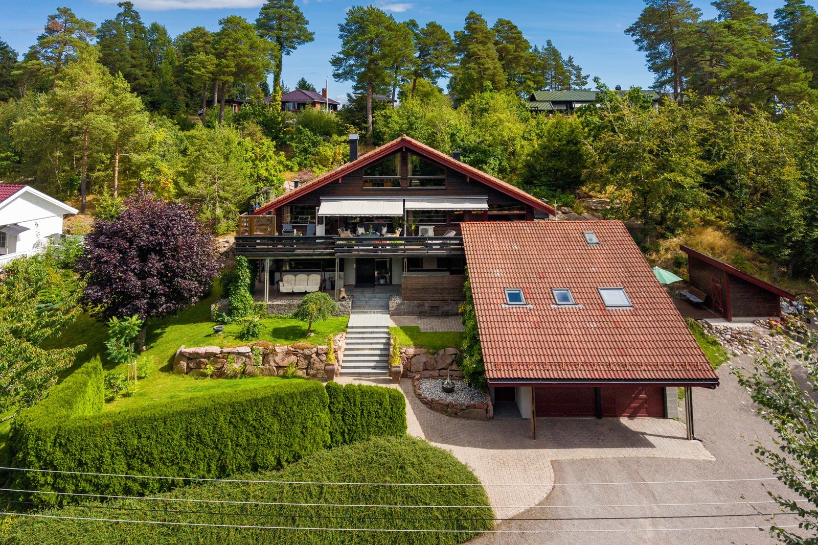 Den etablerte hagen byr på variert beplantning, naturstein og hyggelige uteplasser, mens den romslige gårdsplassen gir gode parkeringsmuligheter. Galleribilde