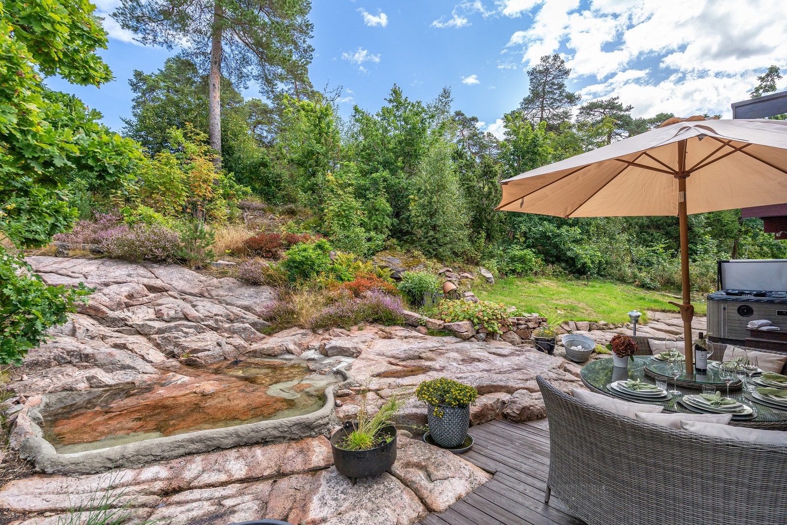 Rundt huset er det opparbeidet en flott og innholdsrik hage med variert beplantning, naturstein, blomsterbed og flere hyggelige uteplasser. Galleribilde