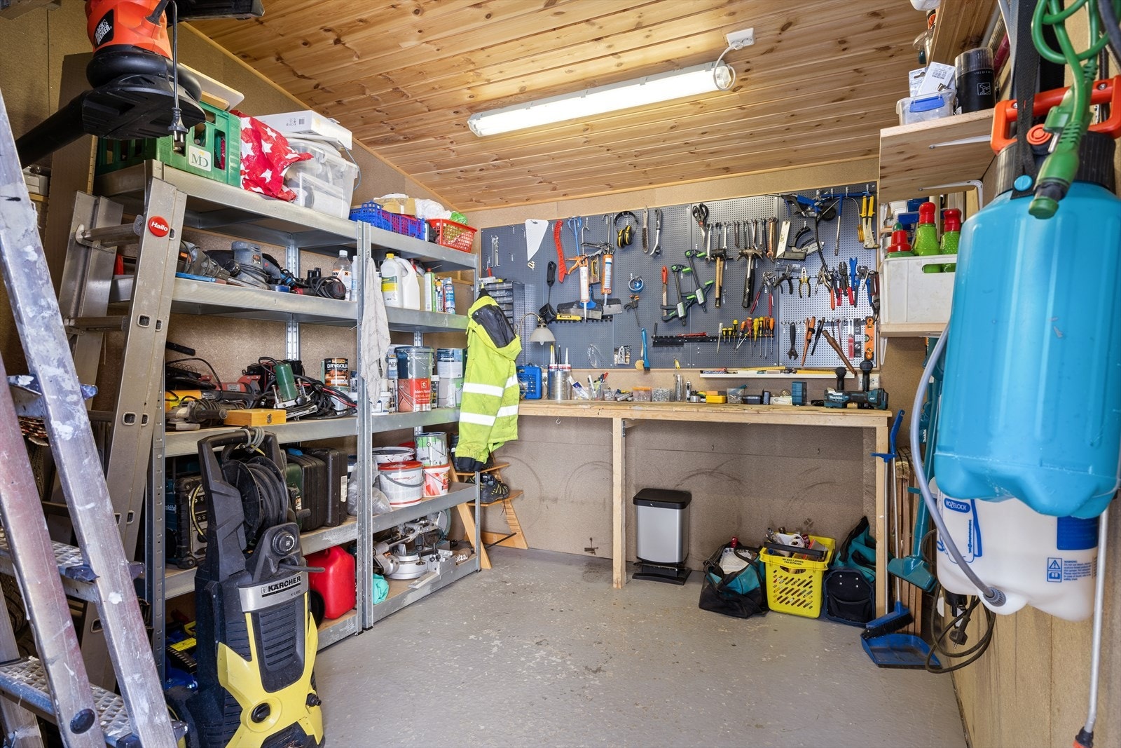 Bodbygget er innredet med hyller og arbeidsbenk, ideelt for verksted eller hobbyrom. Galleribilde