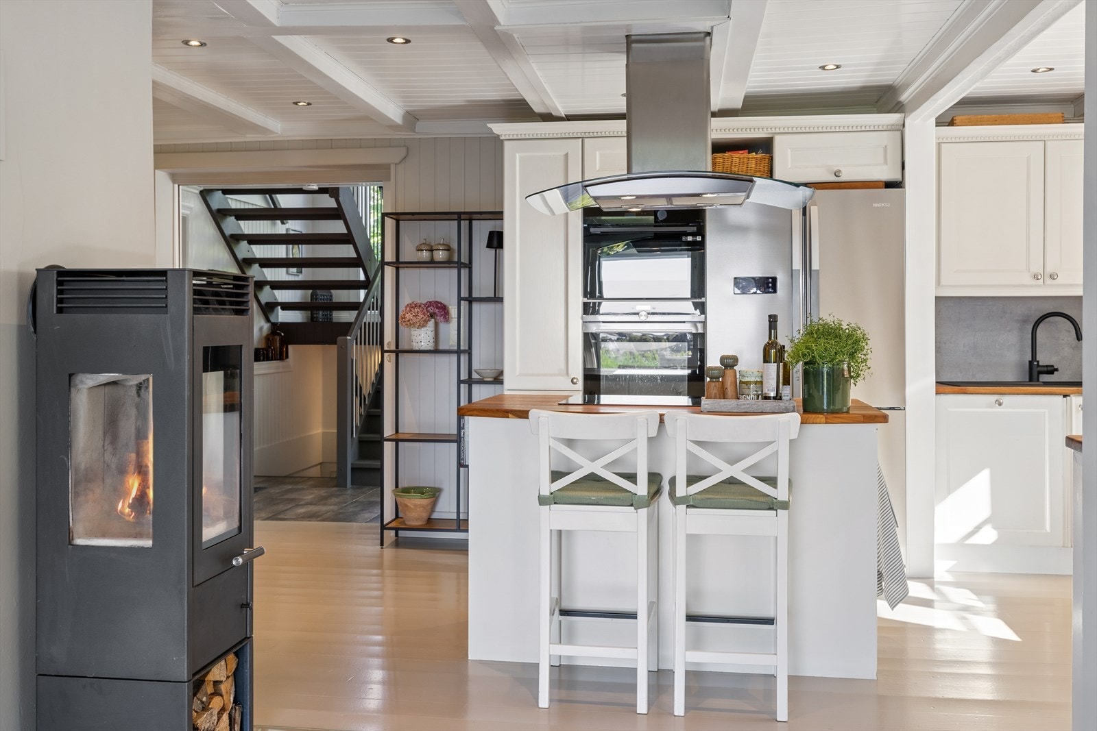 Peisovnen mellom kjøkken og stue gir ekstra varme og hygge. Galleribilde