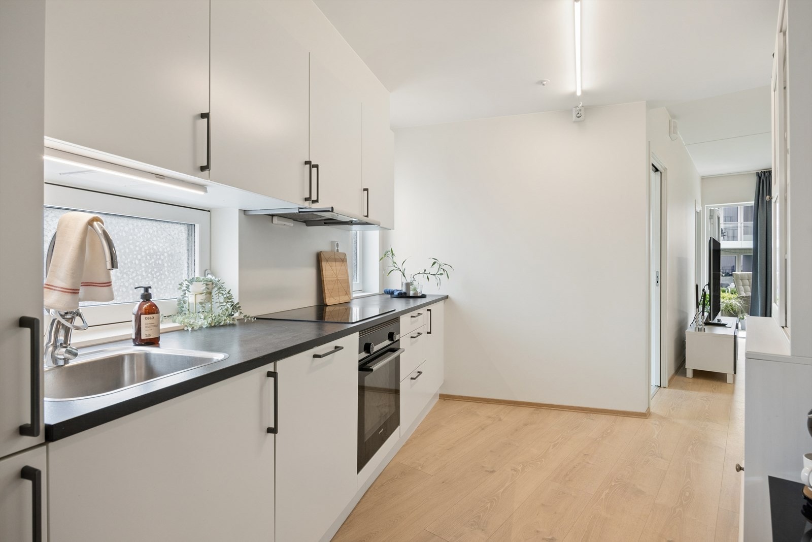 Moderne kjøkkenløsning med effektiv planløsning og god arbeidsflate. Galleribilde