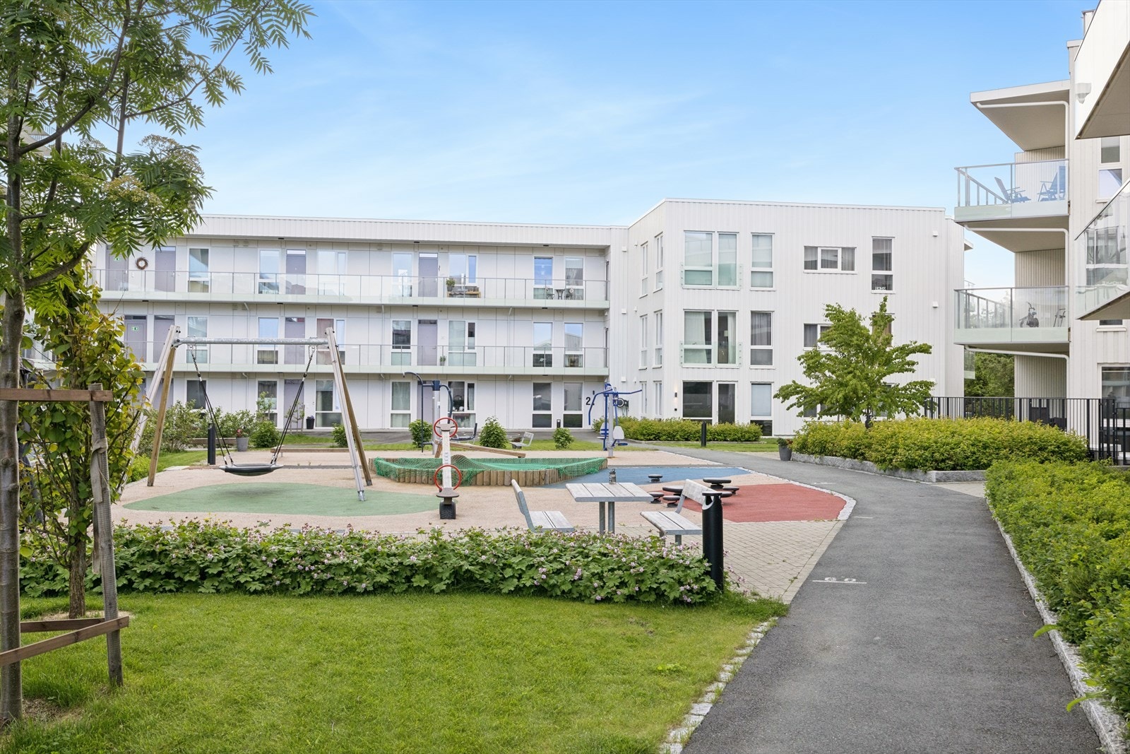 Velholdt fellesområde med moderne bebyggelse rundt. Galleribilde