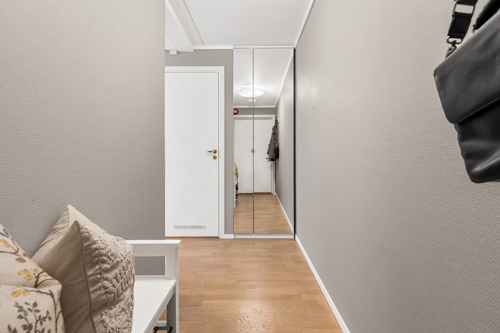 Entré/gang med parkett på gulv, malt strietapet på vegger og slett flate i himling Galleribilde