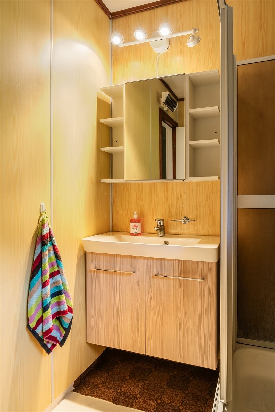 Badet er utstyrt med dusjkabinett og et moderne servantskap som gir god oppbevaringsplass. Galleribilde