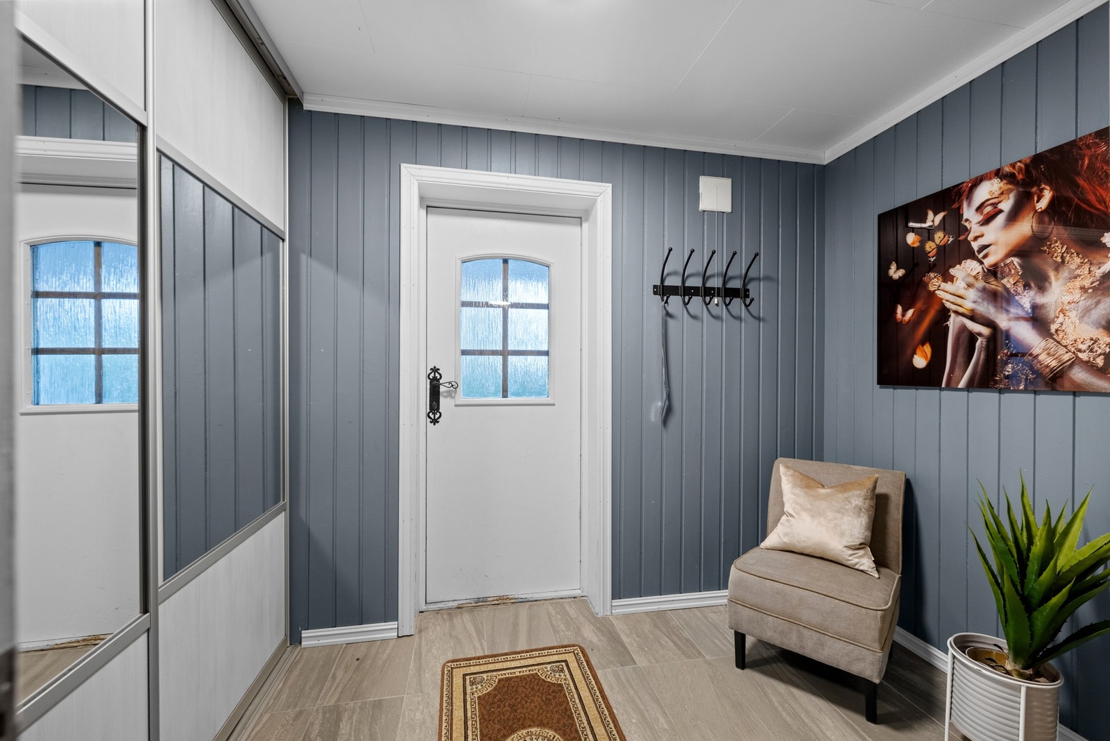 Entréen gir et hyggelig førsteinntrykk av boligen, med god plass til å henge fra seg yttertøy og sette fra seg sko. Her er det også en stor skyvedørsgarderobe som gir praktisk oppbevaringsplass og gjør det enkelt å holde inngangspartiet ryddig. Galleribilde
