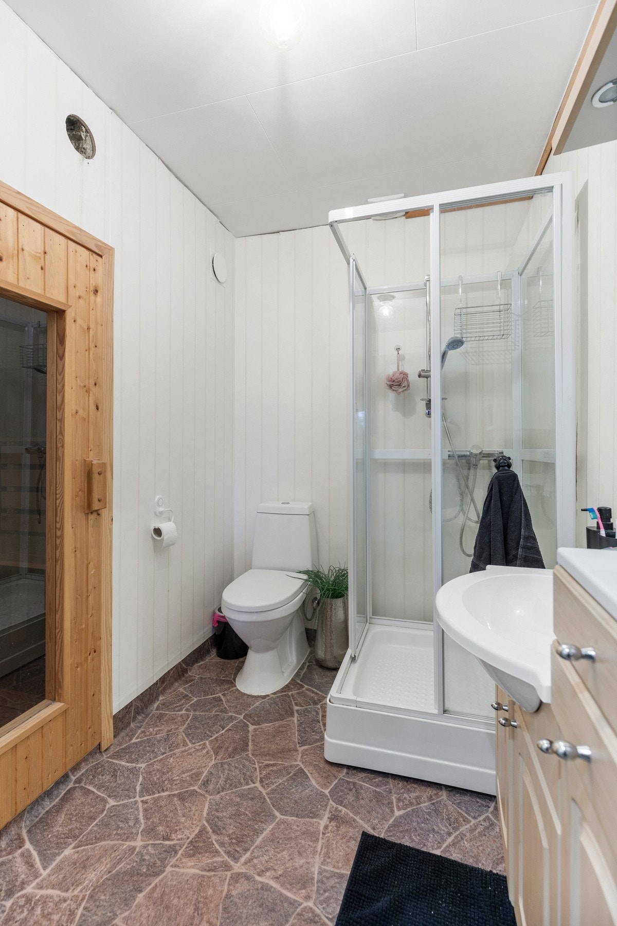 Badet er utstyrt med varmekabler i gulv, dusjkabinett, toalett, servant med underskap, elektrisk avtrekk og tilkomst til badstue. Galleribilde