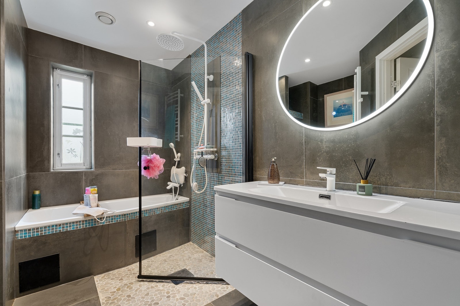 Badet inneholder både dusjhjørne med regnfallsdusj, og badekar med vegghengt armatur. Galleribilde