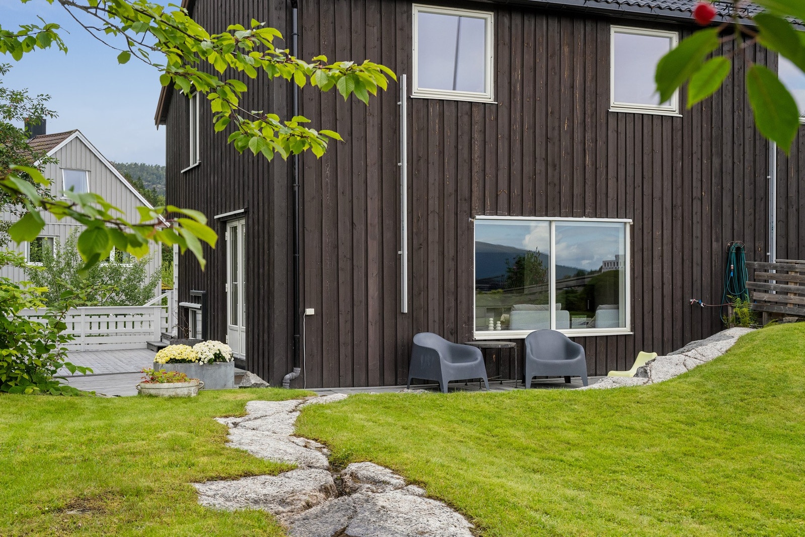 Halvpart av vertikaldelt tomannsbolig med pent opparbeidet uteområde, beliggende i et etablert boligområde på Byåsen. Galleribilde