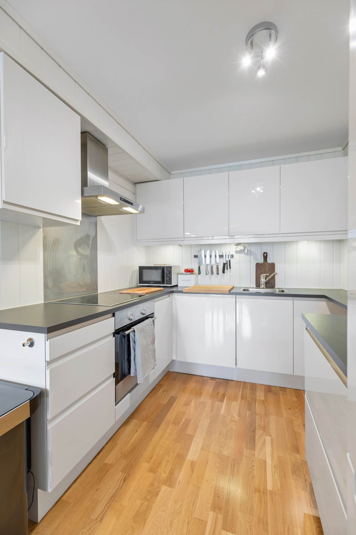 Kjøkkenet er utstyrt med ventilatorhette over integrert komfyr, integrert oppvaskmaskin og laminat benkeplate med nedfelt oppvaskkum. Galleribilde
