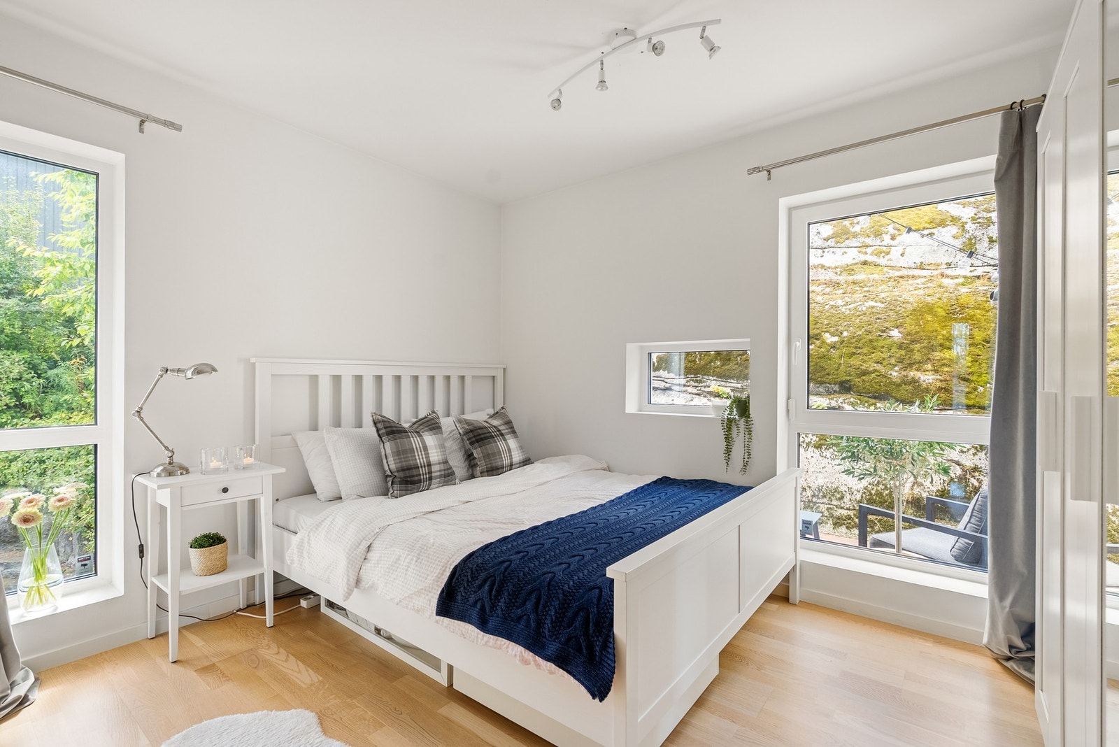 Et innbydende soverom med flere vinduer som slipper inn godt med dagslys, og god plass i garderobe Galleribilde