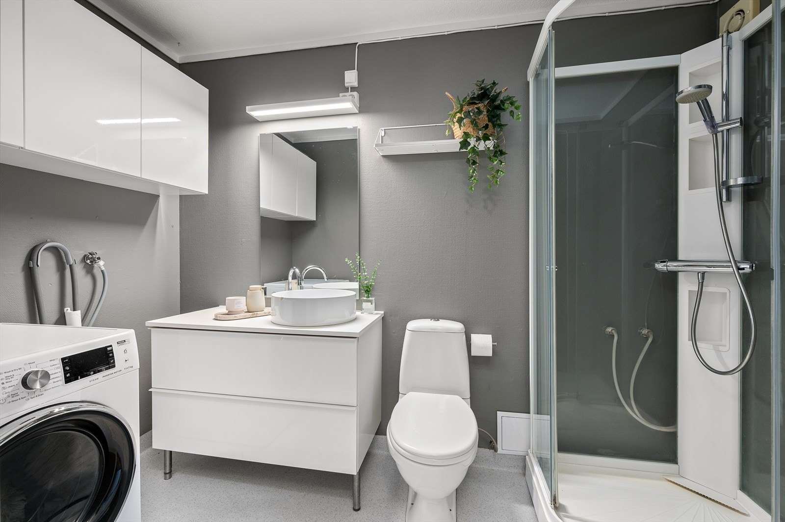 Badet er på 4 m² med praktisk baderomsinnredning, dusjkabinett og ferdig opplegg for vaskemaskin. Galleribilde
