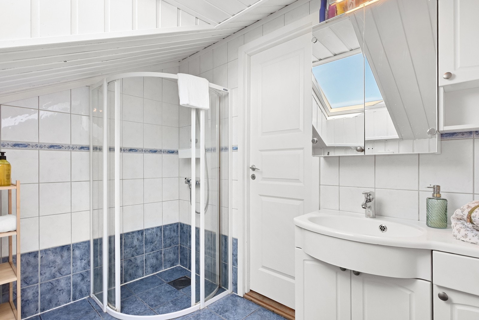 Badet er innredet med dusjhjørne, servantinnredning, speilskap, wc og takvindu. Galleribilde