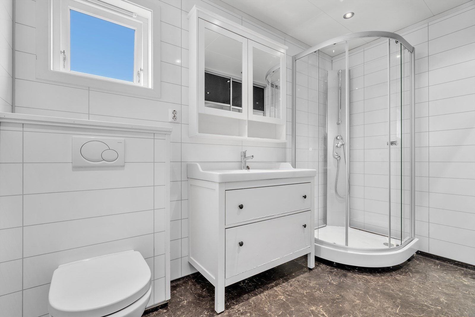 Badet har gulvvarme, dusjkabinett, vegghengt toalett og opplegg for vaskemaskin. Galleribilde