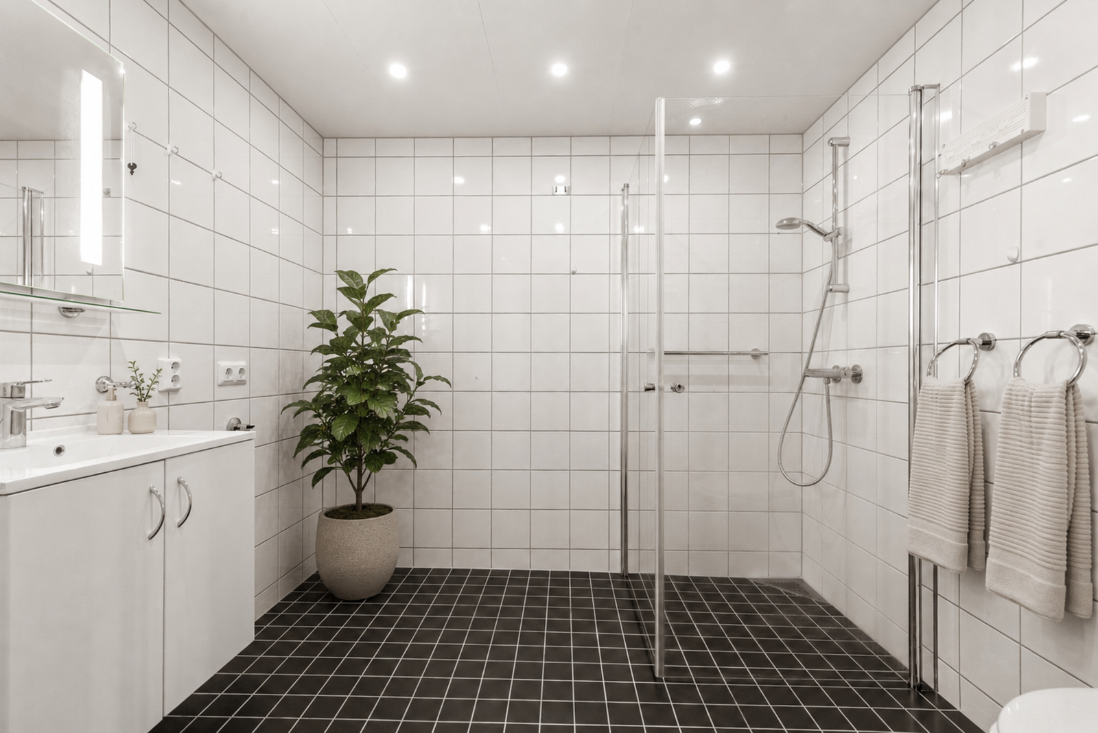 Badet har et moderne og tidløst uttrykk med flislagte overflater og en praktisk innredning. Galleribilde