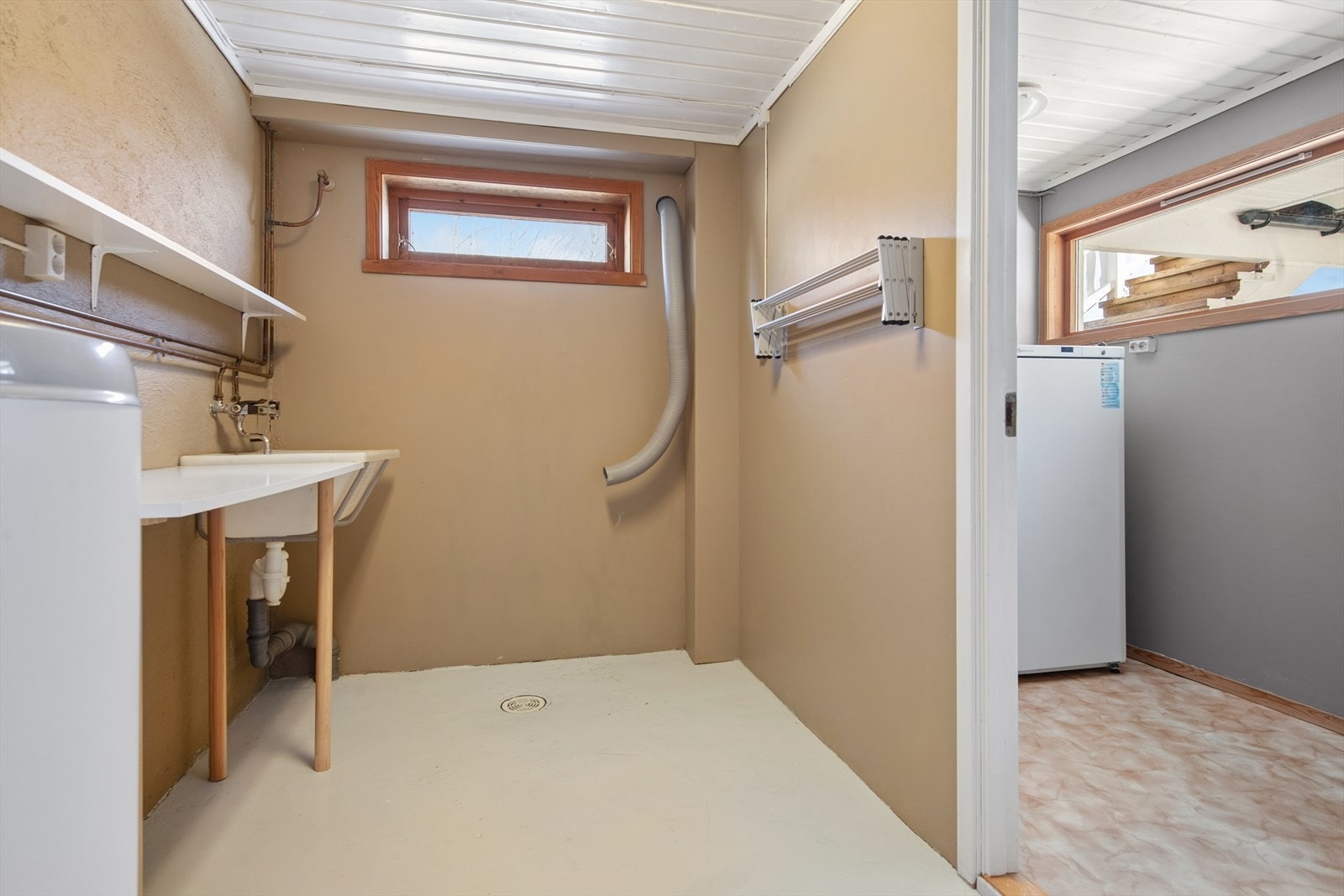 Praktisk vaskerom i kjelleren med utslagsvask, varmtvannsbereder og trykktank fra 2023. Fra vaskerommet er inngang til bod med god lagringsplass og direkte utgang til uterommet. Galleribilde