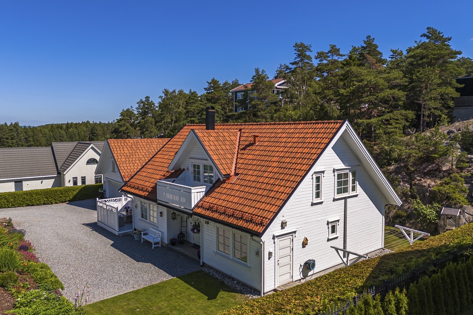 Tomten er pent opparbeidet med gressplen, hekk og gruset gårdsplass Galleribilde