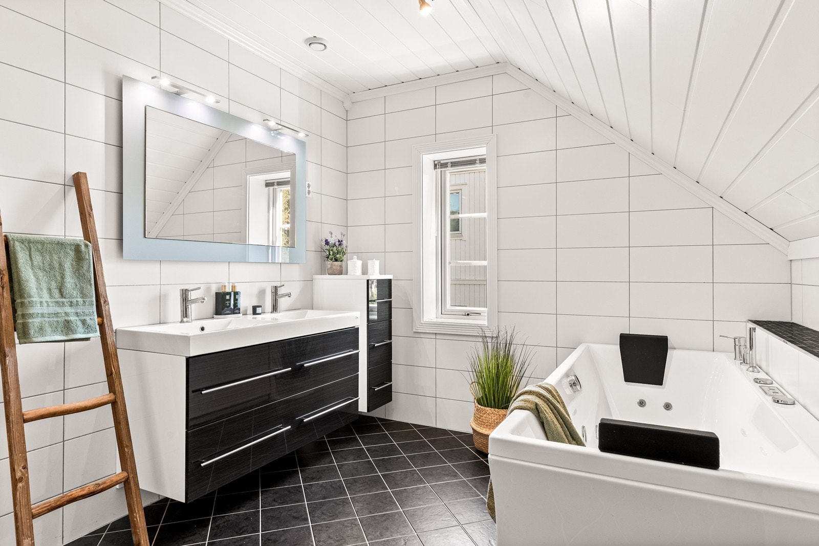 Badet i andre etasje er innredet med badekar med massasjefunksjon, WC, og dobbelservant med tilhørende skuffer og speil Galleribilde