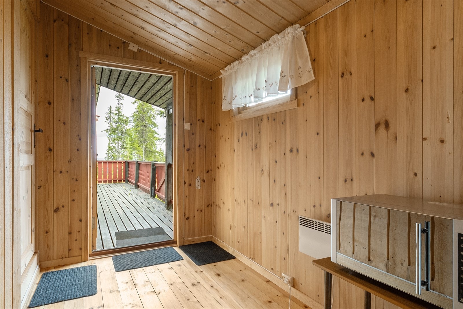Inngangsparti med panel på vegger og tak, og lakkert furugulv. Galleribilde