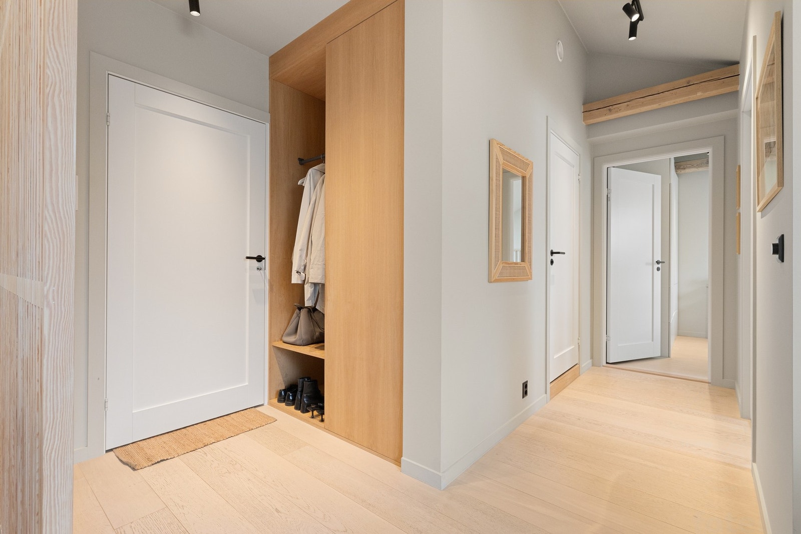 Lys og luftig entré som gir et godt inntrykk av leiligheten. Her er det et praktisk innebygget oppbevaringssystem til å henge fra seg yttertøy. Galleribilde