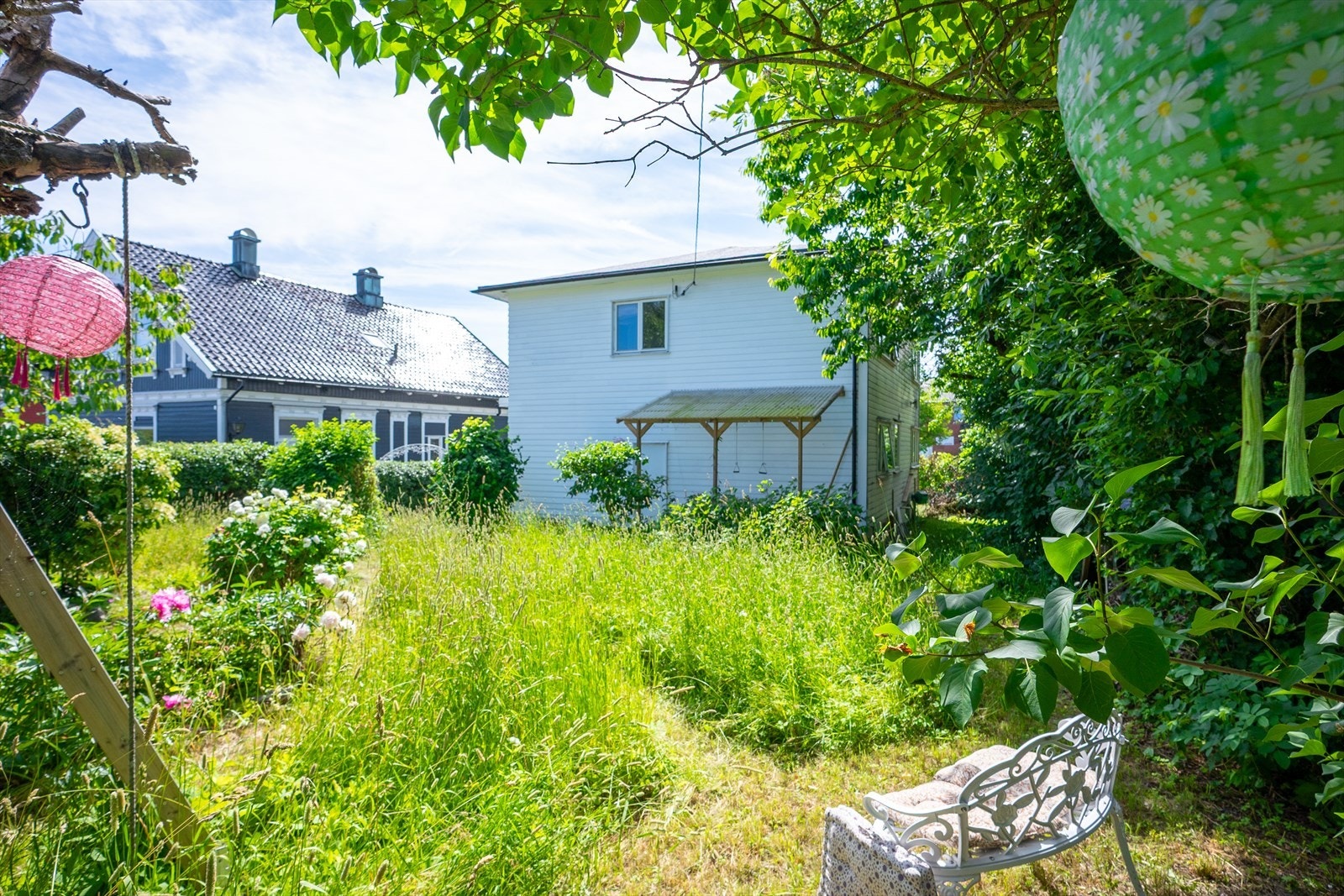 Nyt rolige stunder i den frodige hagen, omgitt av blomstrende beplantning. Galleribilde