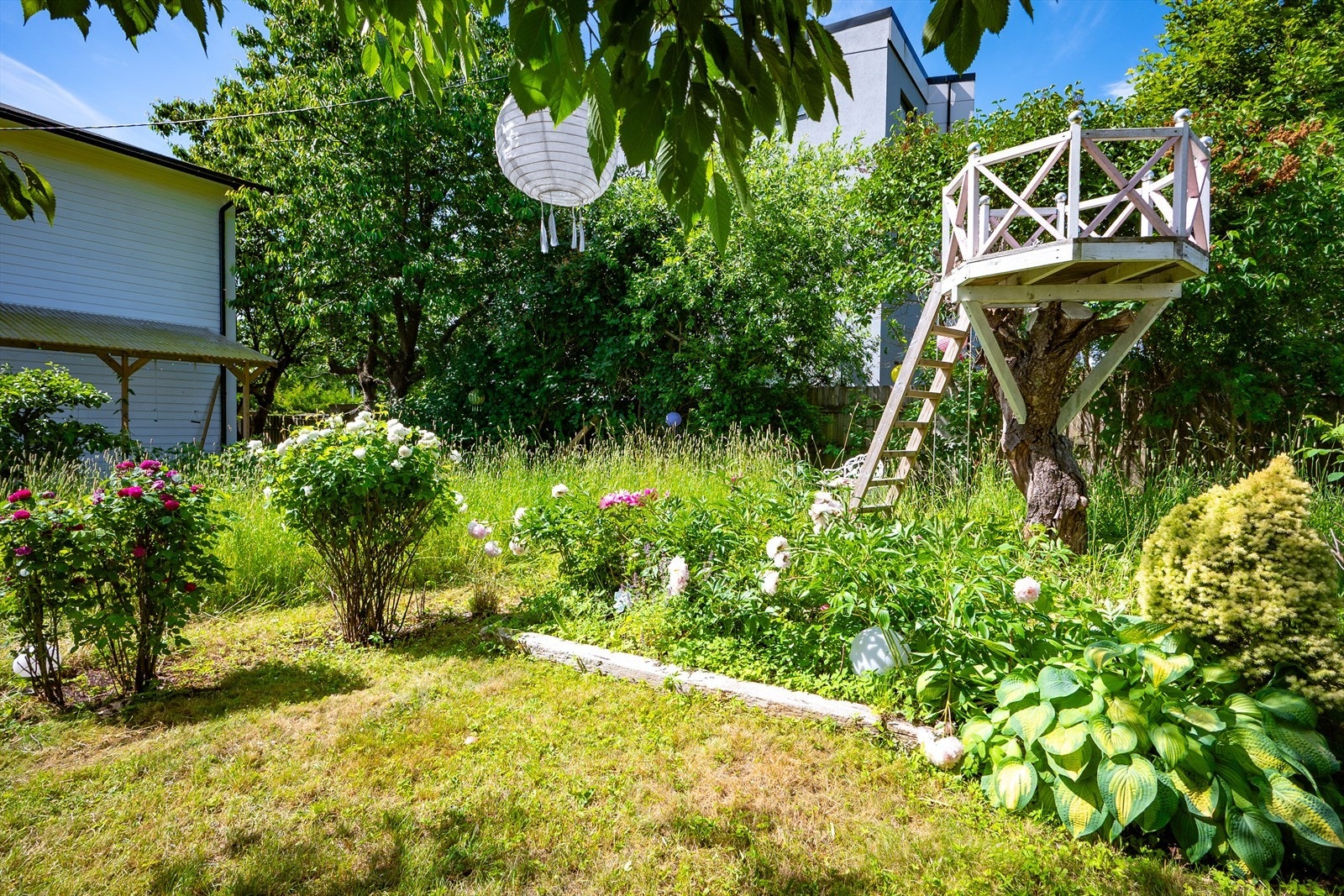 En hage med blomstrende beplantning, grønne omgivelser gir eiendommen en helt egen karakter. Galleribilde