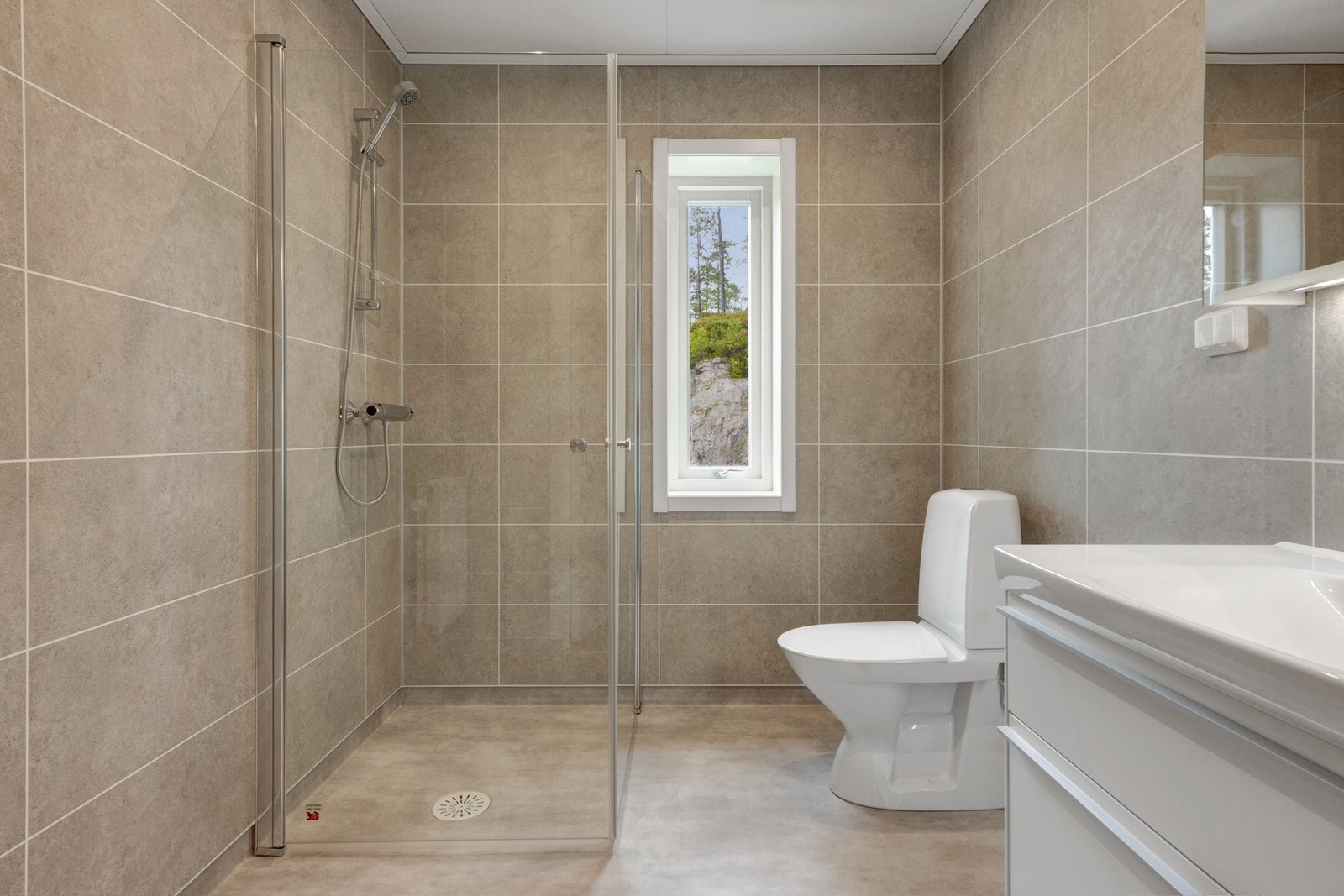 Badet er på 5 kvm og har baderomsplater i flismønster og vinyl på gulv med gulvvarme. Galleribilde