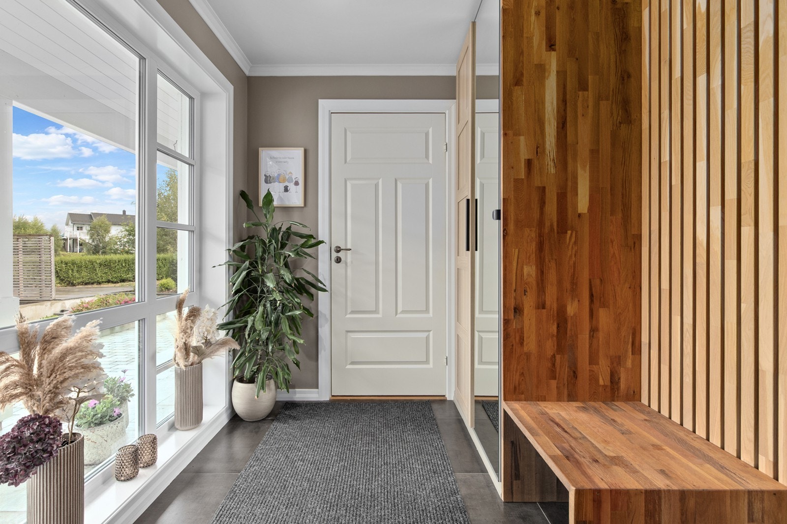 En lys og elegant entré med gjennomførte materialvalg, god oppbevaringsplass . Galleribilde