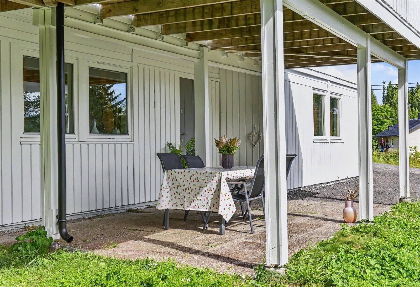Overbygd uteplass under terrassen, med utgang til hagen. Galleribilde
