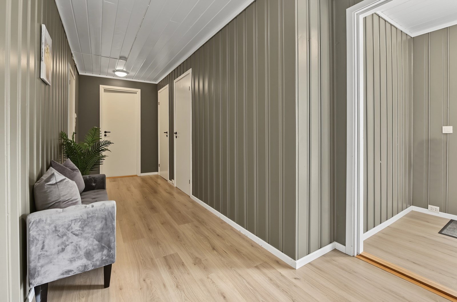 Gangen i underetasjen har panel på veggene og laminat på gulvet. Galleribilde