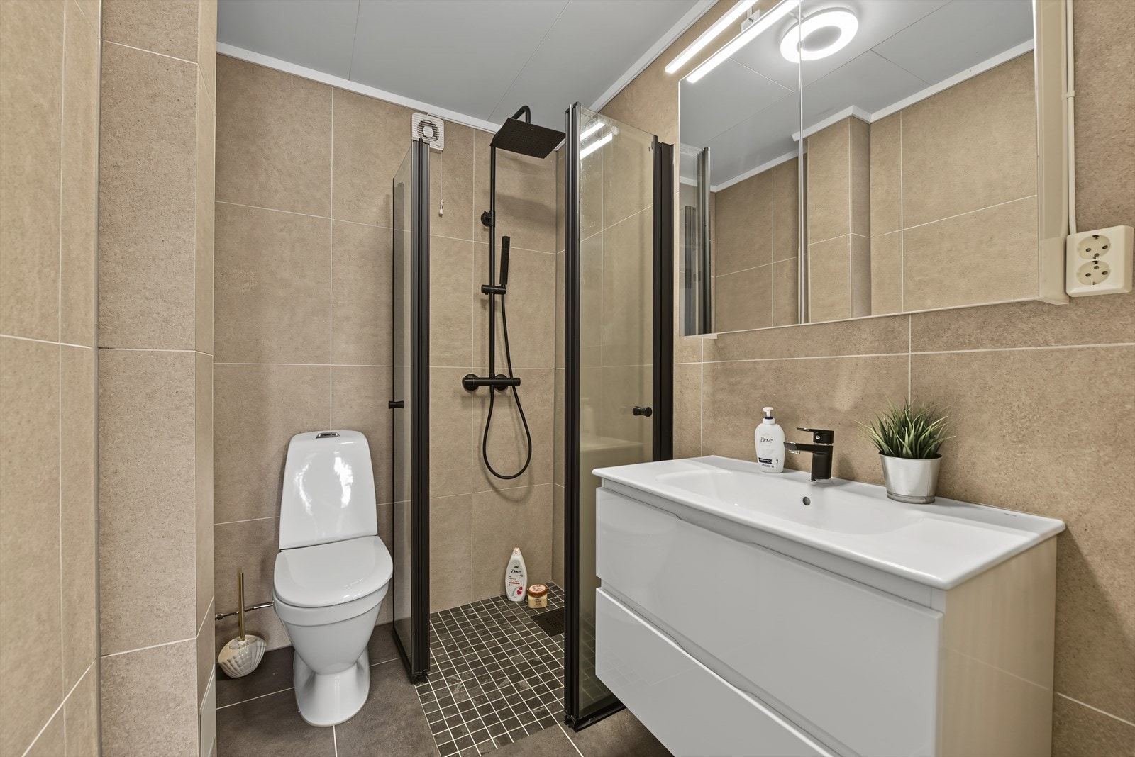 Badet er utstyrt med gulvvarme, dusjhjørne og gulvmontert toalett. Galleribilde