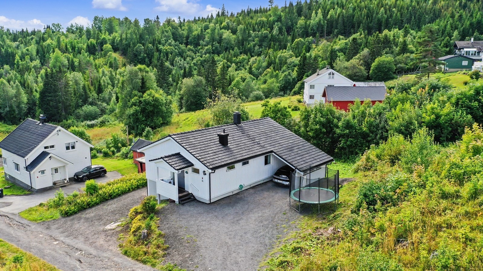 Gruset gårdsplass og carport gir gode parkeringsforhold på egen tomt. Galleribilde