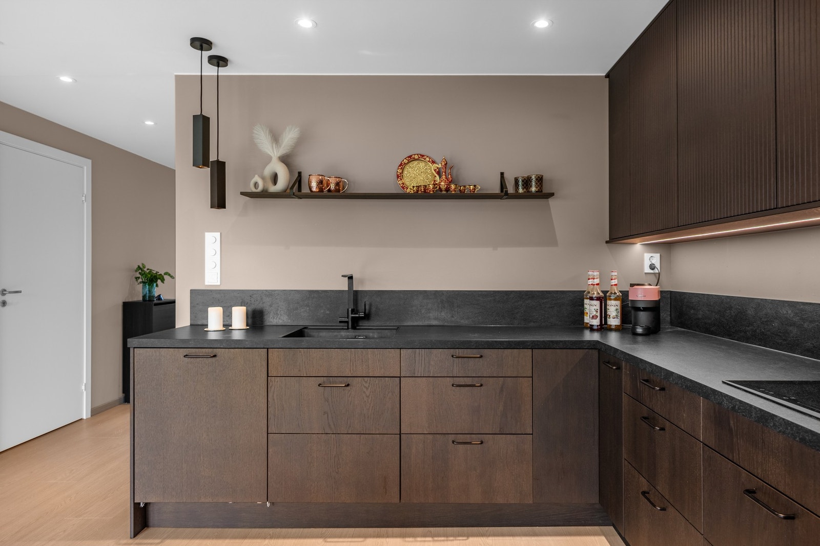 Planlimt sort kum med sort blandebatteri, sorte lyspendler og LED stripe innfelt i overskap! Galleribilde