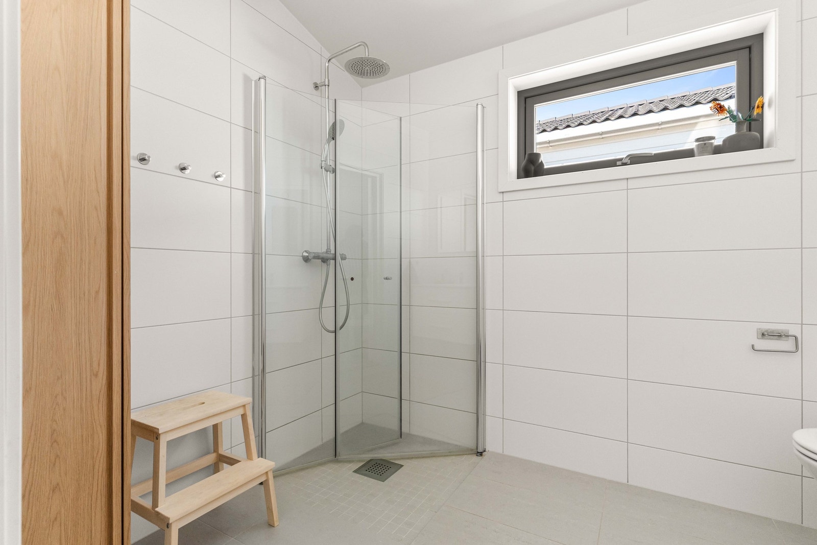 Badet er utstyrt med dusjhjørne, vegghengt toalett og servantinnredning. Galleribilde