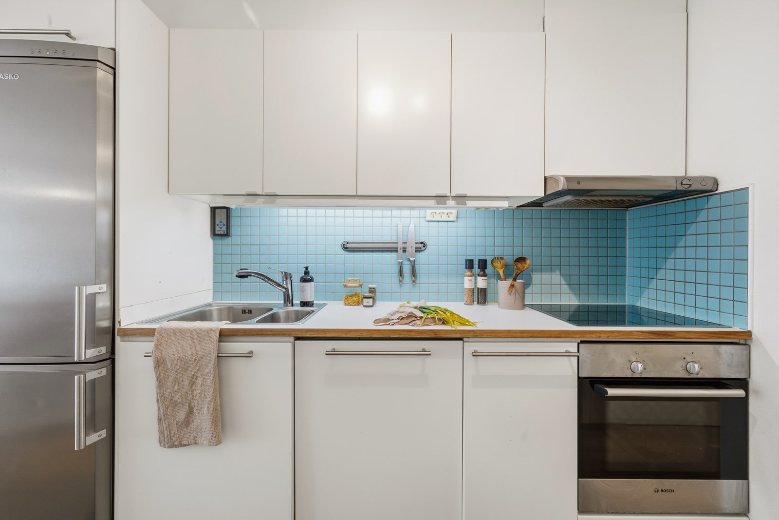 Innredningen byr på gode arbeidsflater og rikelig med oppbevaringsplass, samtidig som plasseringen tett på spiseområdet legger til rette for en enkel og velfungerende hverdag. Galleribilde
