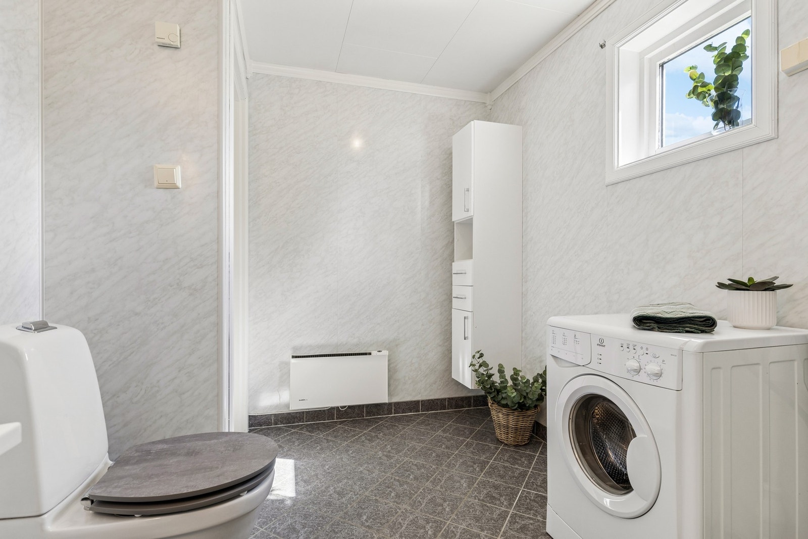 Badet har elektriske varmekabler i gulvet og opplegg for vaskemaskin. Galleribilde