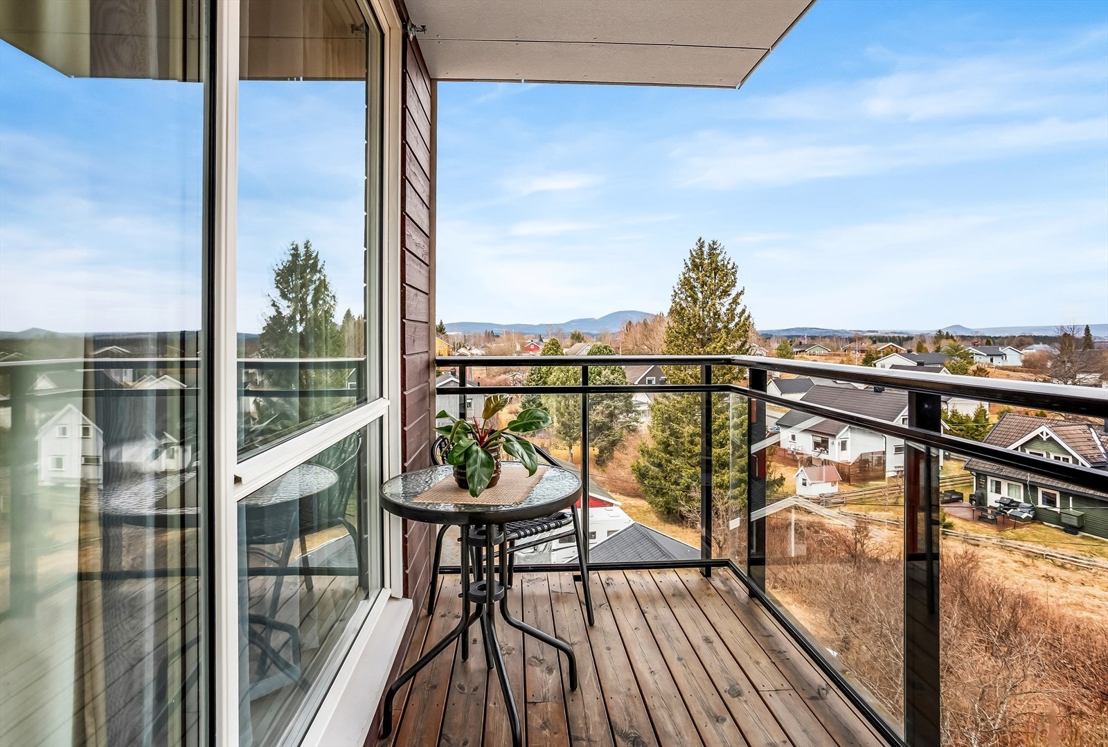 Balkongen er belagt med impregnerte terrassebord og har rekkverk i stål og glass. Galleribilde