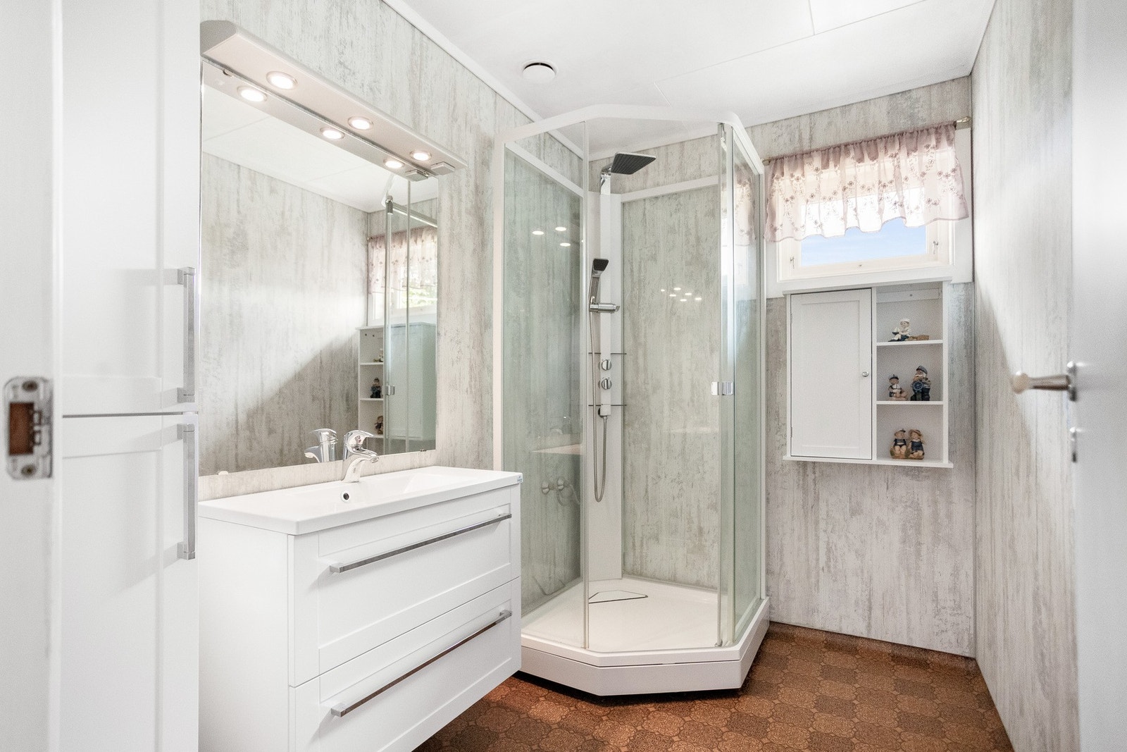 Badet på hovedplan er utstyrt med nyere dusjkabinett og servant/innredning. Badet er enkelt oppgradert med våtromsplater på vegg. Galleribilde