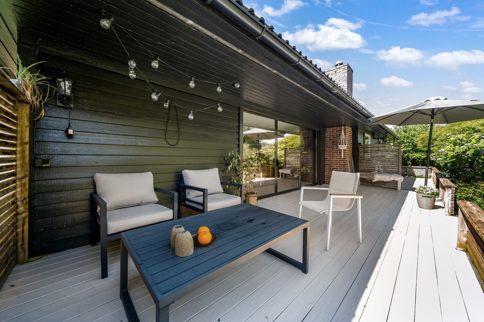 Stor og solrik terrasse med flere soner for både avslapning og hyggelige sammenkomster. Galleribilde