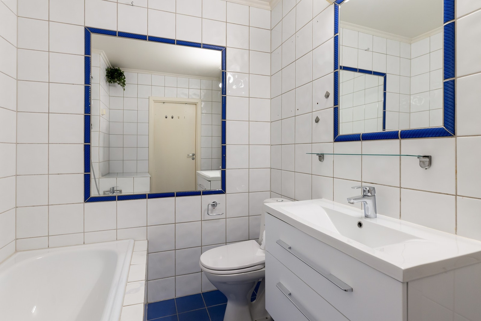 Bad med varmekabler i gulv, innfliset badekar, servant og gulvstående toalett. Galleribilde