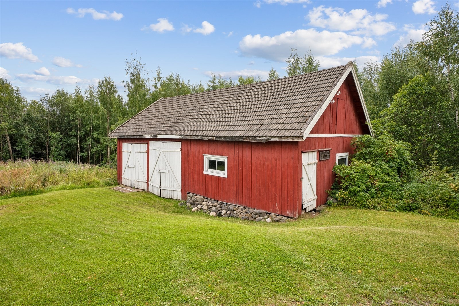 Den romslige låven på 80 m² gir rikelig med lagringsplass og har egen garasjedel. Galleribilde